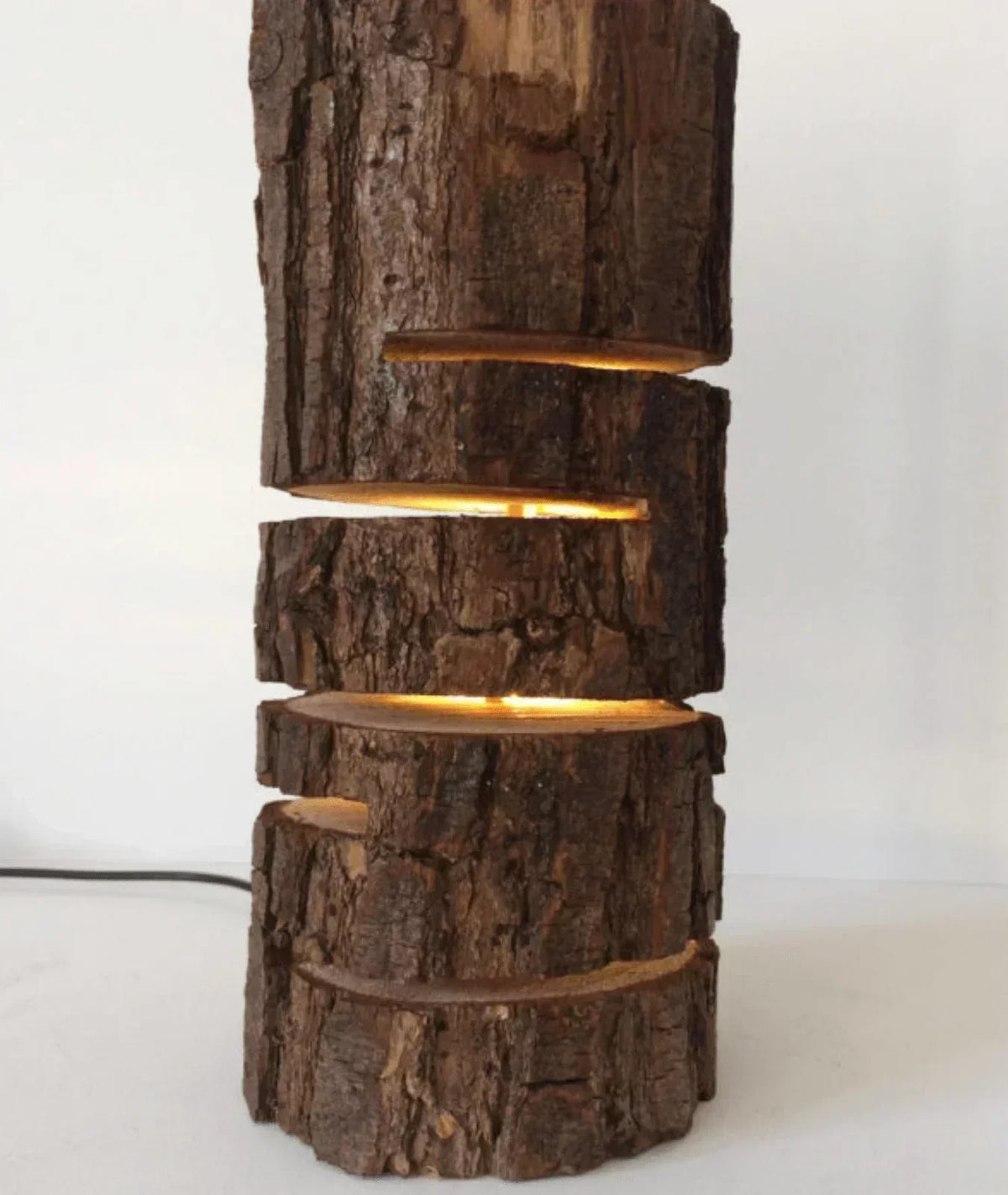 “Glowing Log Wooden Lamp with burnt edges and vertical glowing slits, handcrafted from natural wood with built-in LED for warm rustic ambiance.”