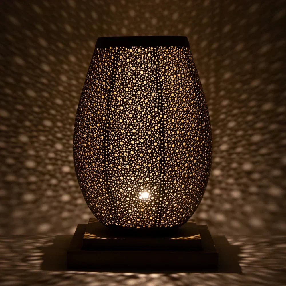 Decorative lamp with textured surface casting shadows on a wall