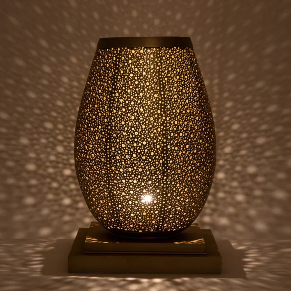 Decorative lamp with a textured surface casting shadows on a wall