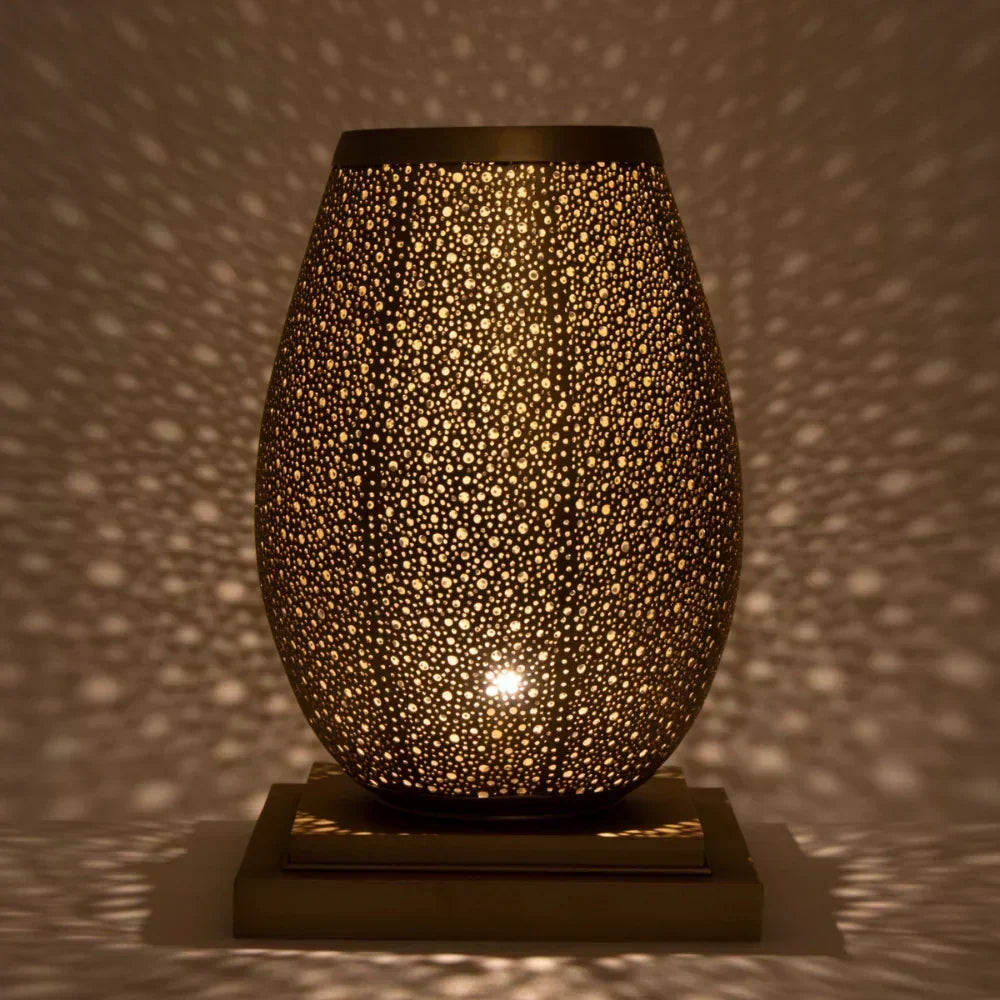 Decorative lamp with a textured surface casting shadows on a wall