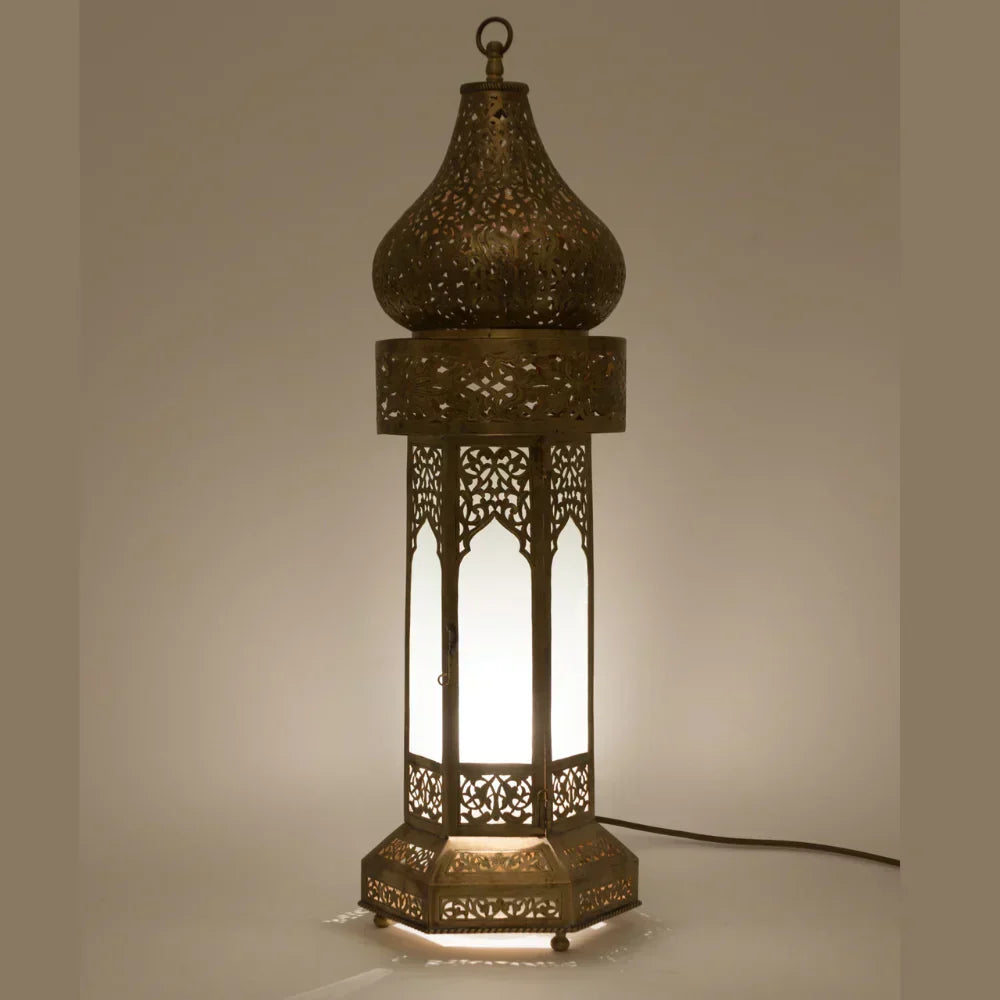 Decorative lamp with intricate cut-out design on a neutral background