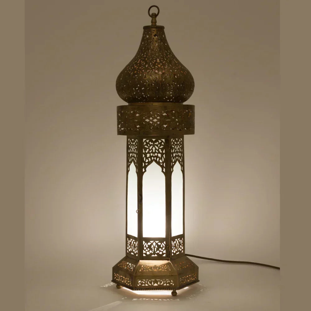 Decorative lamp with intricate cut-out design on a neutral background