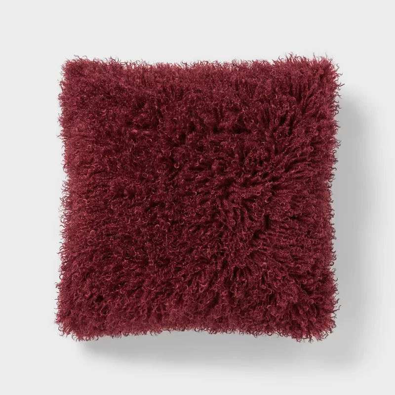 Fluffy red-brown cushion on a light gray background Berry Purple