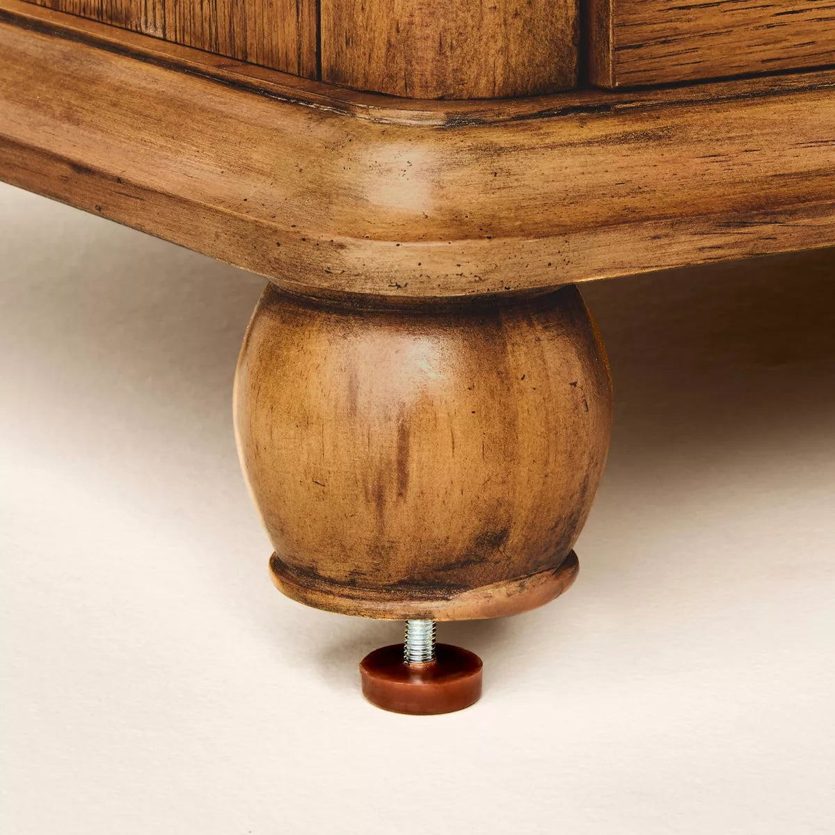 A dark brown colored dresser with six drawers, featuring round knobs, is adorned with a white lamp, books, a bowl, and a candle holder on top Aged Oak.