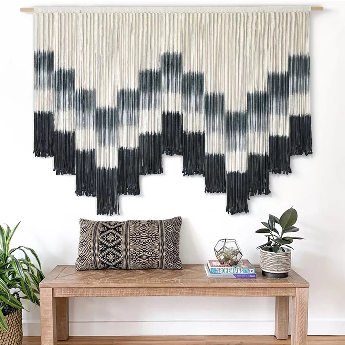 Black and white patterned wall art with fringe on a white background