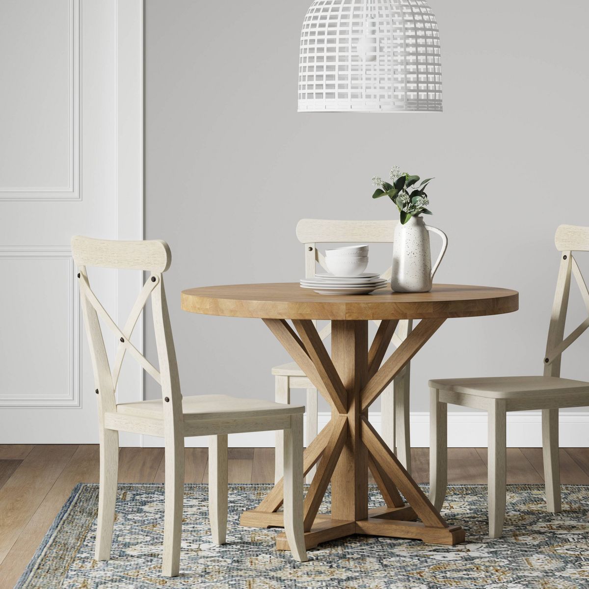 Round wooden table with a geometric base design on a white background.