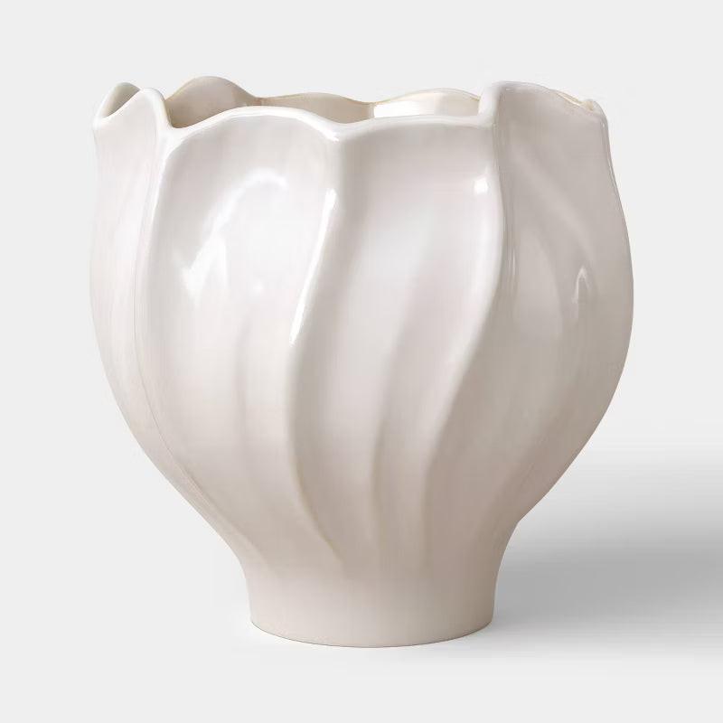 A white colored planter with a wavy, scalloped edge and smooth, glossy finish.