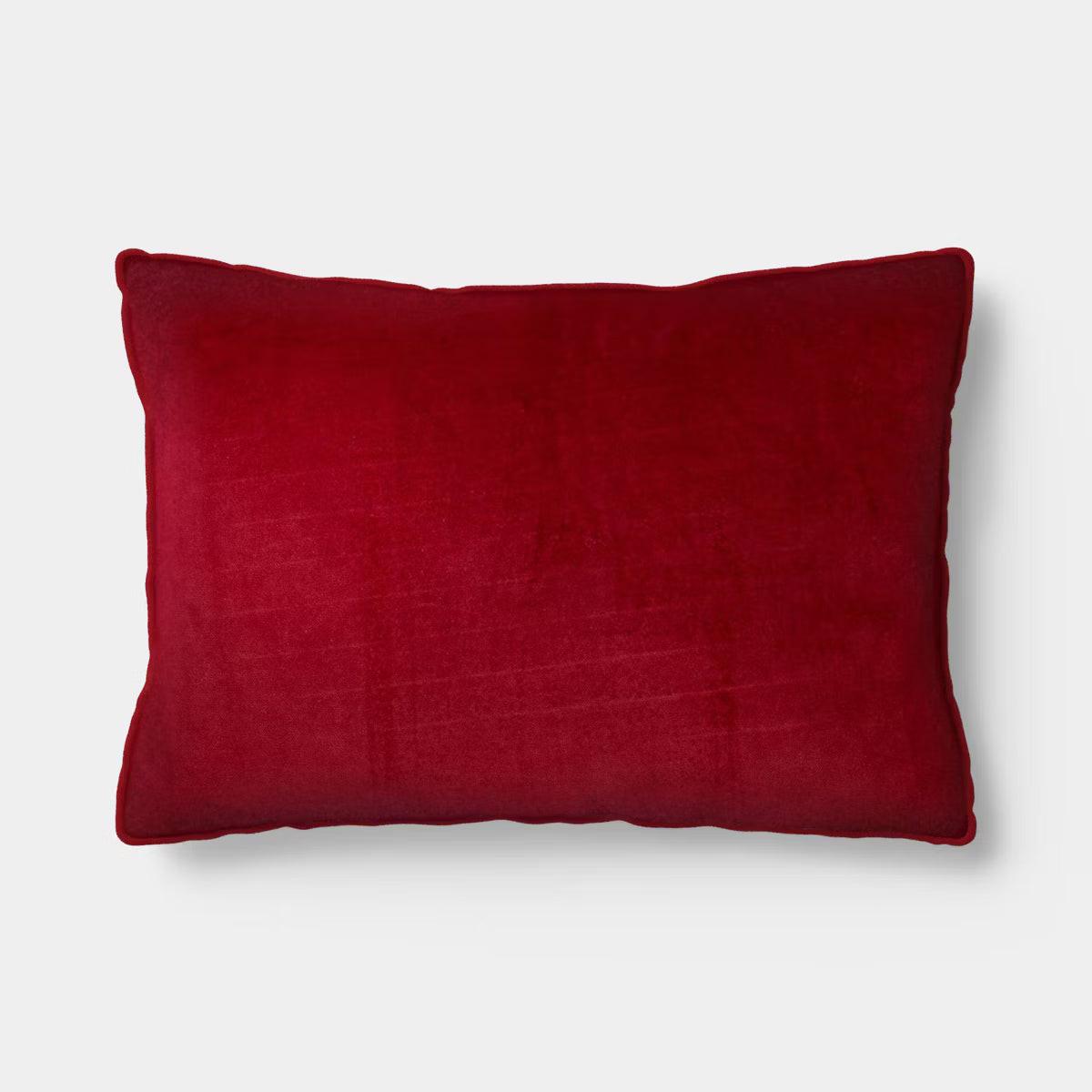 Rectangular light pink colored pillow with red colored piping and the word & quot love quot embroidered in red.
