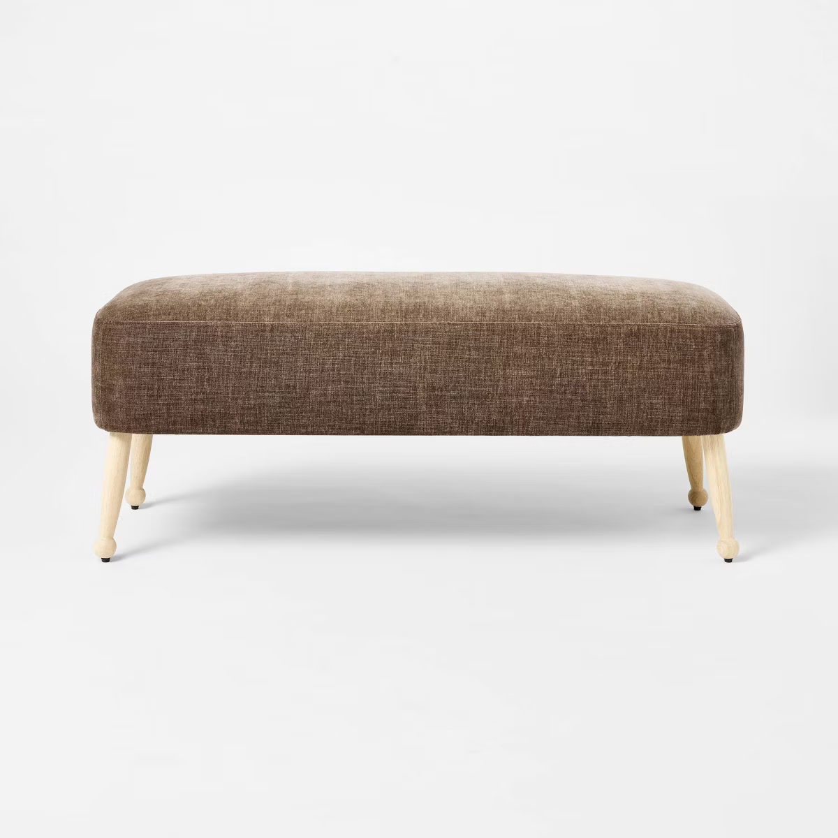 Brown upholstered bench with wooden legs on a white background Browm