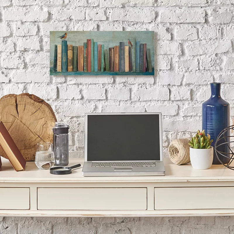 Desk setup with laptop, books, and decorative items against a white brick wall.