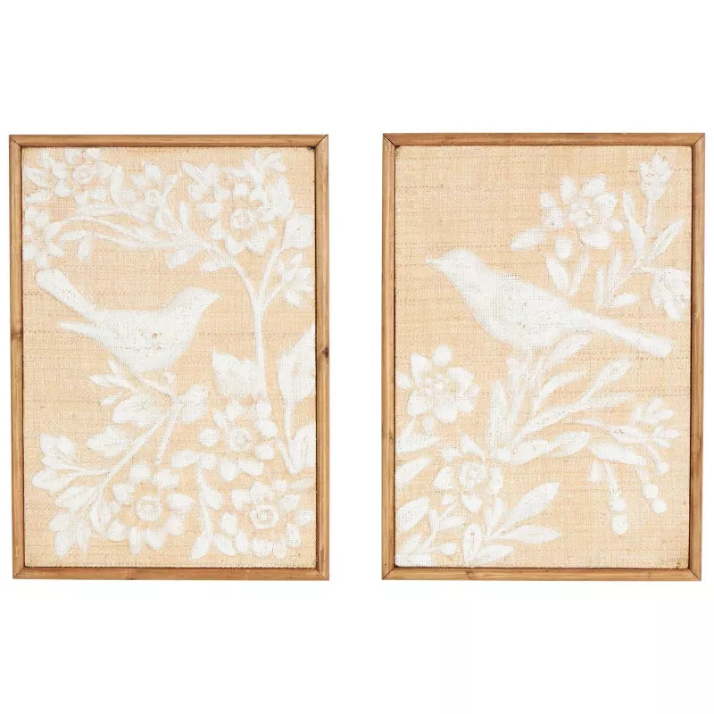 Two framed wall art pieces with white floral and bird designs on a beige background.
