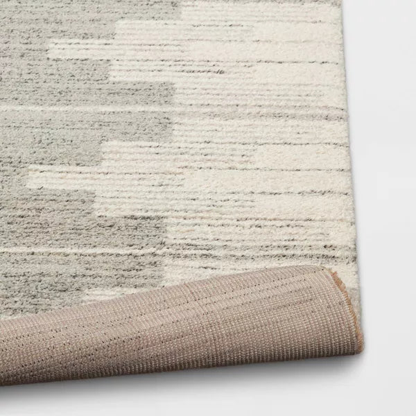 Textured area rug with a neutral color palette on a white background