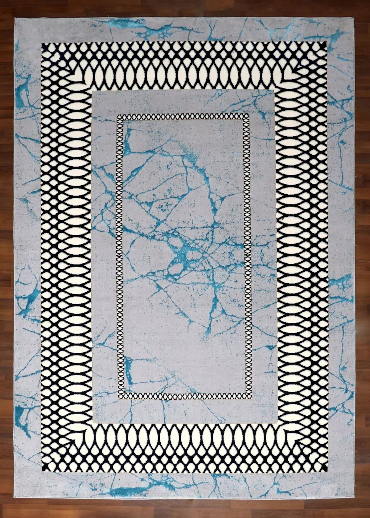 Close-up of a rug with geometric patterns on a wooden floor.