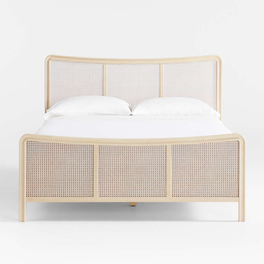Bed with woven headboard and white bedding on a light gray background