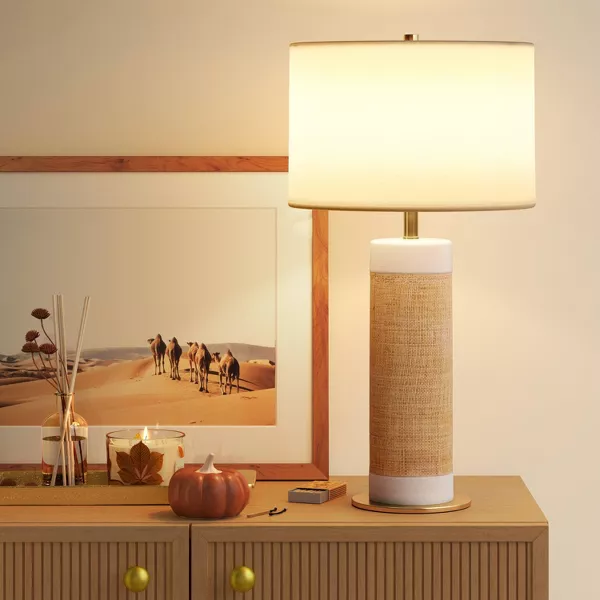 Table lamp with a white shade and woven design base on a light gray background