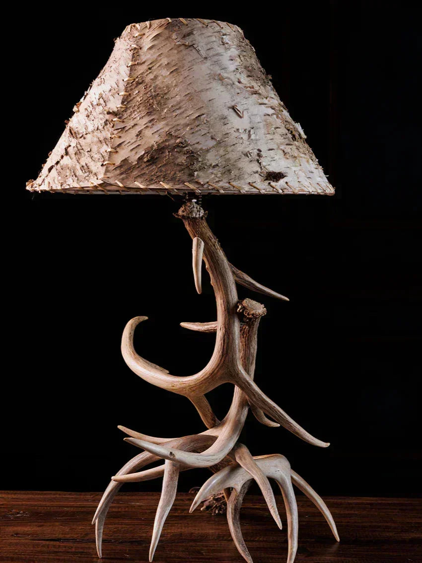 Table lamp with deer antlers and a natural wood shade on a dark background