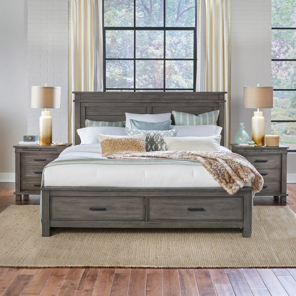Wooden bed with storage drawers in a bedroom setting with lamps and decor.