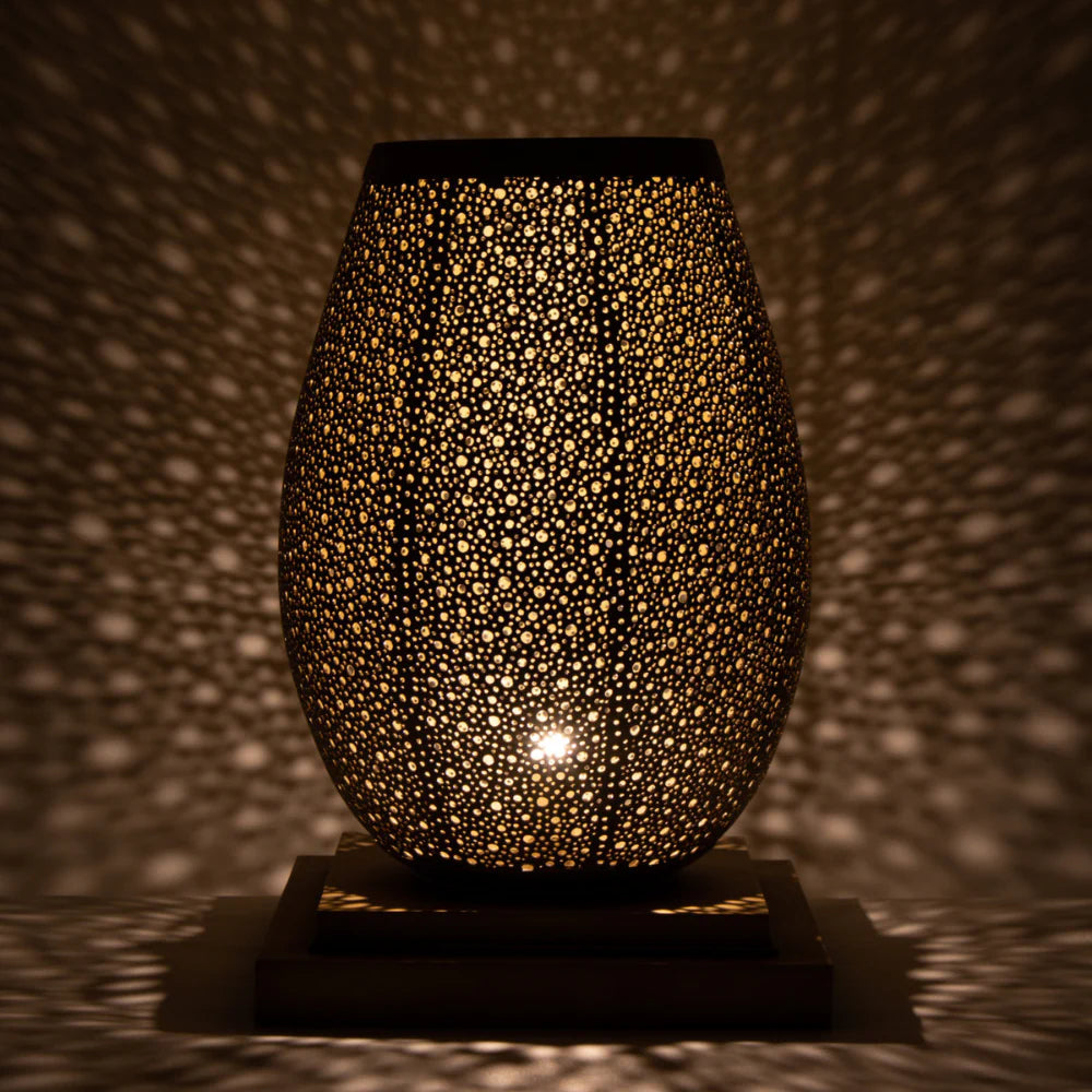 Decorative lamp with textured surface casting shadows on a wall