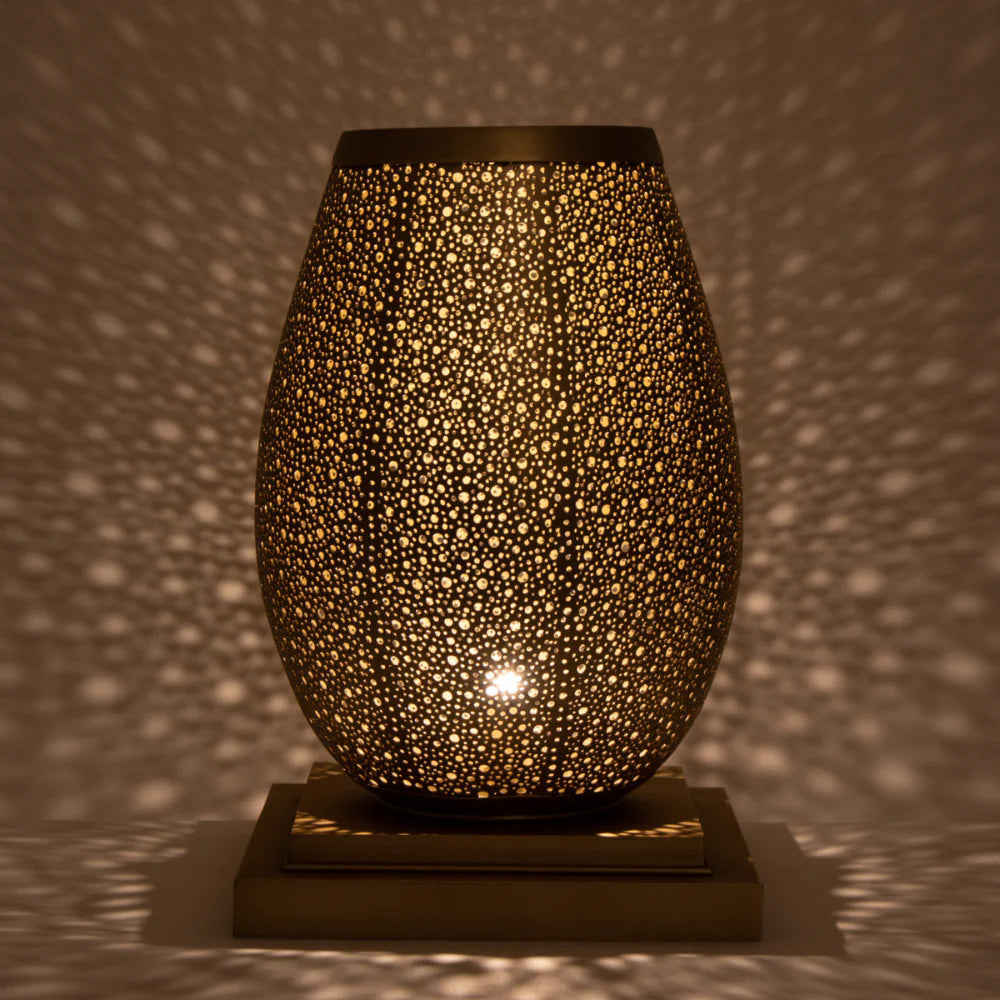 Decorative lamp with a textured surface casting shadows on a wall