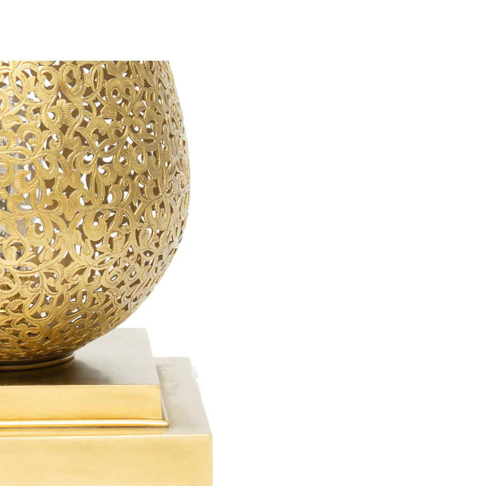 Gold decorative object with intricate patterns on a white background