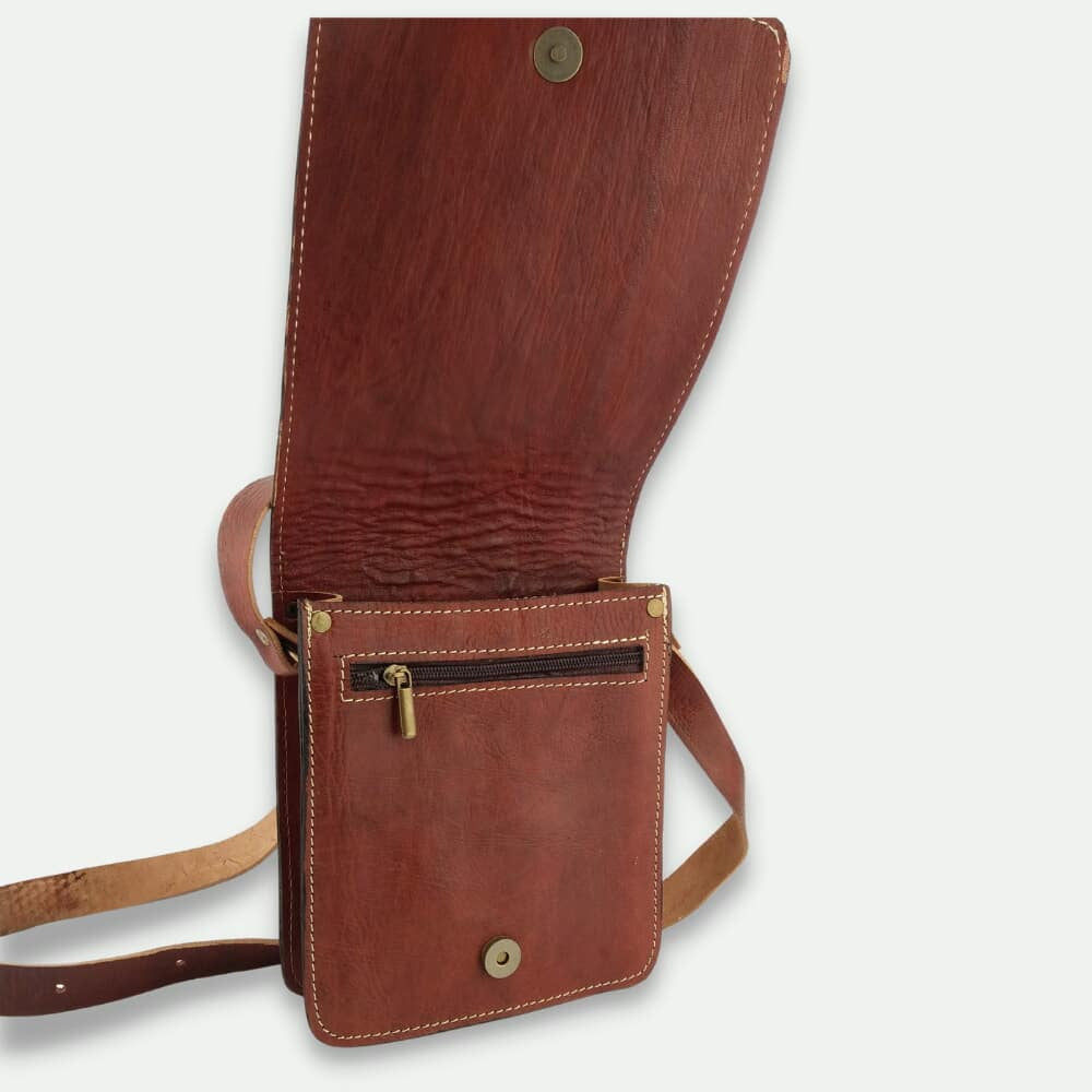 Brown leather crossbody bag with gold accents on a light gray background