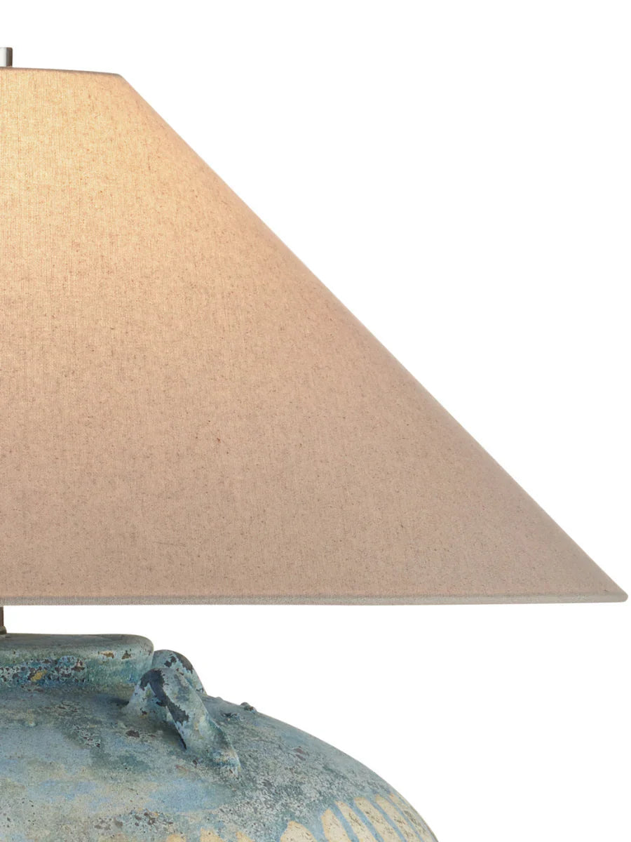 Table lamp with a textured base and beige lampshade on a white background