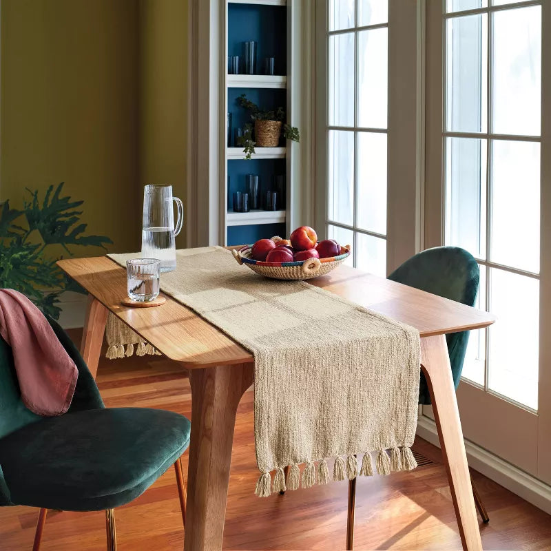 Dining room with wooden table, green chairs, and a bowl of apples.