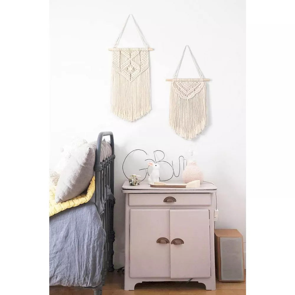 Macrame wall hanging with geometric pattern on a white background