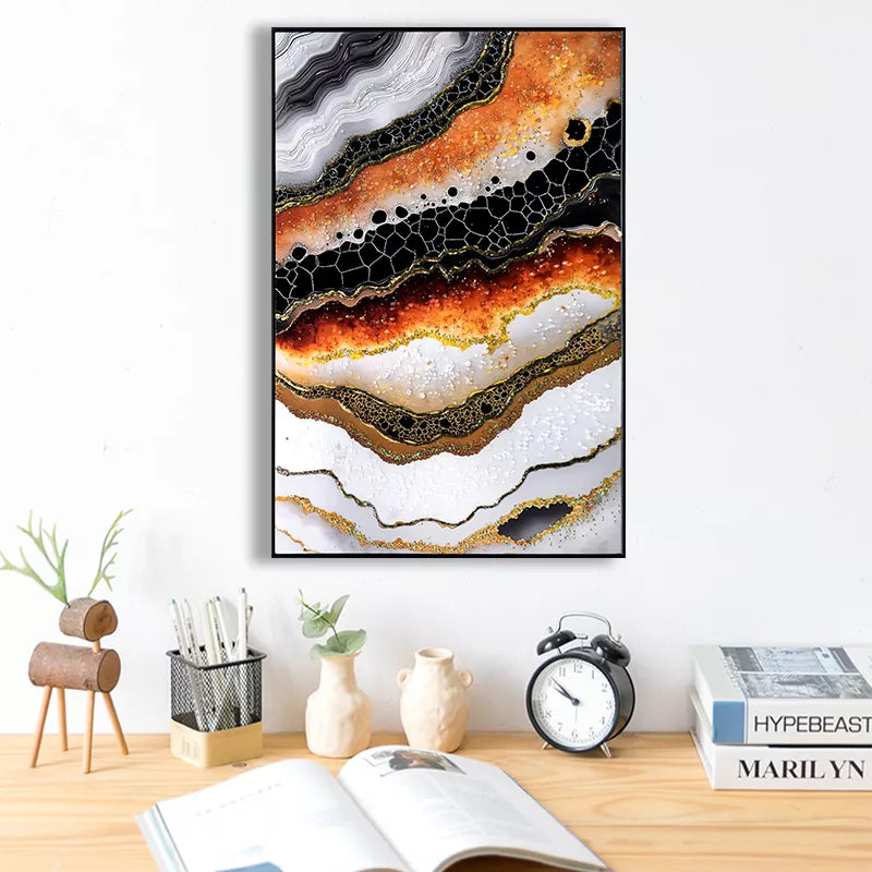 Abstract art piece on a wall above a desk with books and decor items.