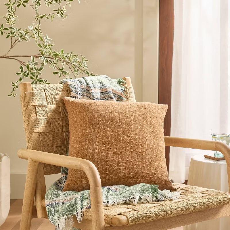 Brown textured pillow with a zipper on a light gray background Natural