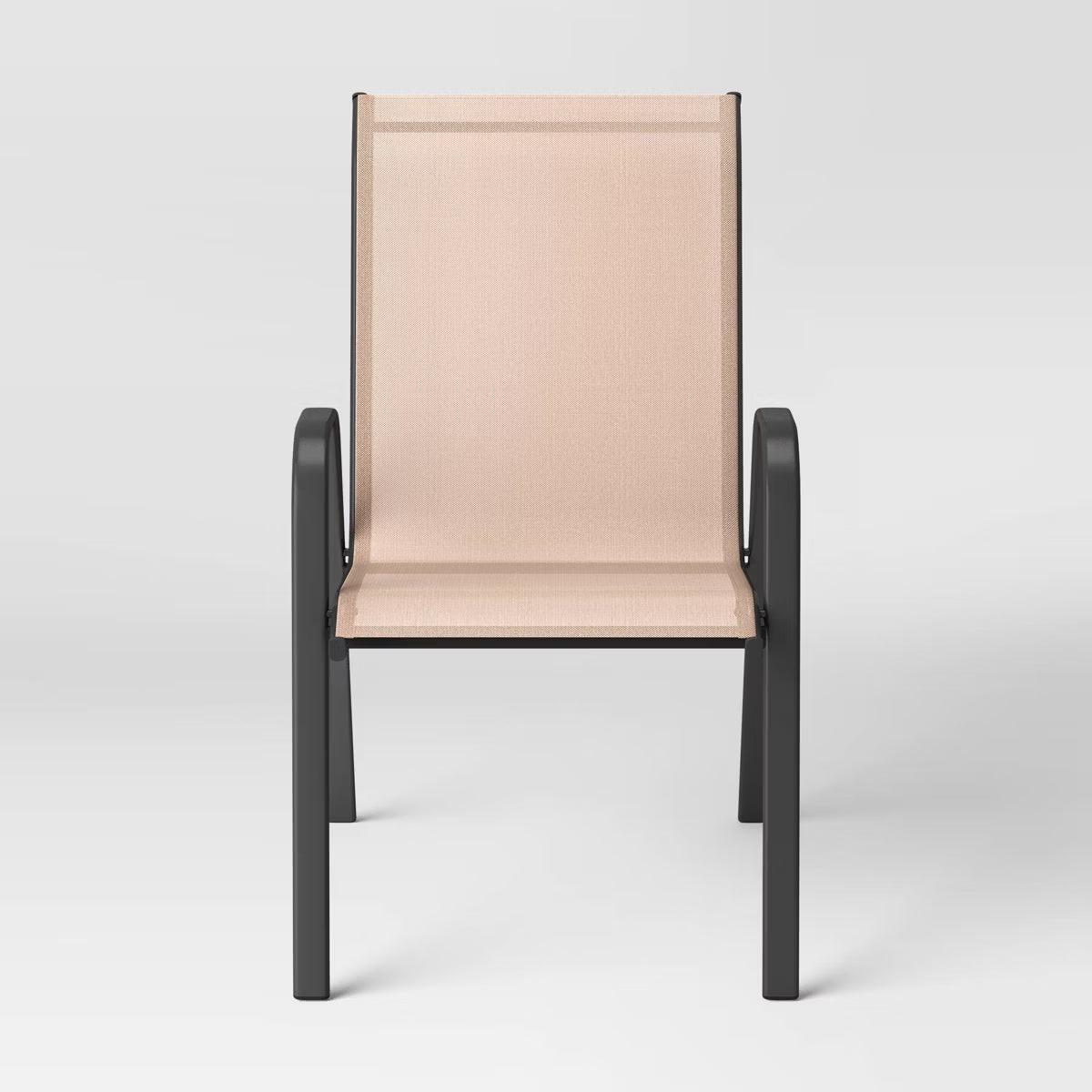 A chair with a beige colored fabric seat and backrest, featuring a black colored metal frame and armrests