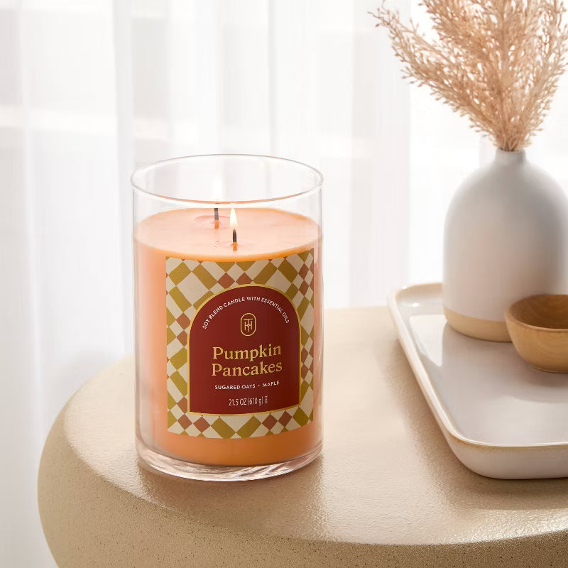 Candle labeled 'Pumpkin Pancakes' with cinnamon sticks and caramel pieces on a light background 21.5oz