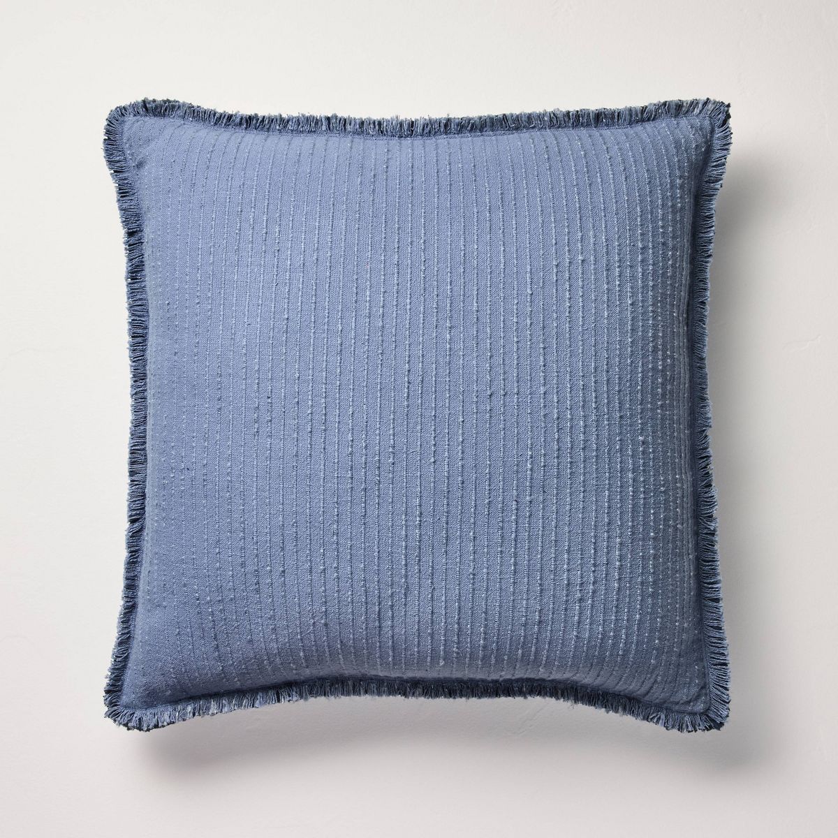 Blue textured blanket with frayed edges on a gray background Navy