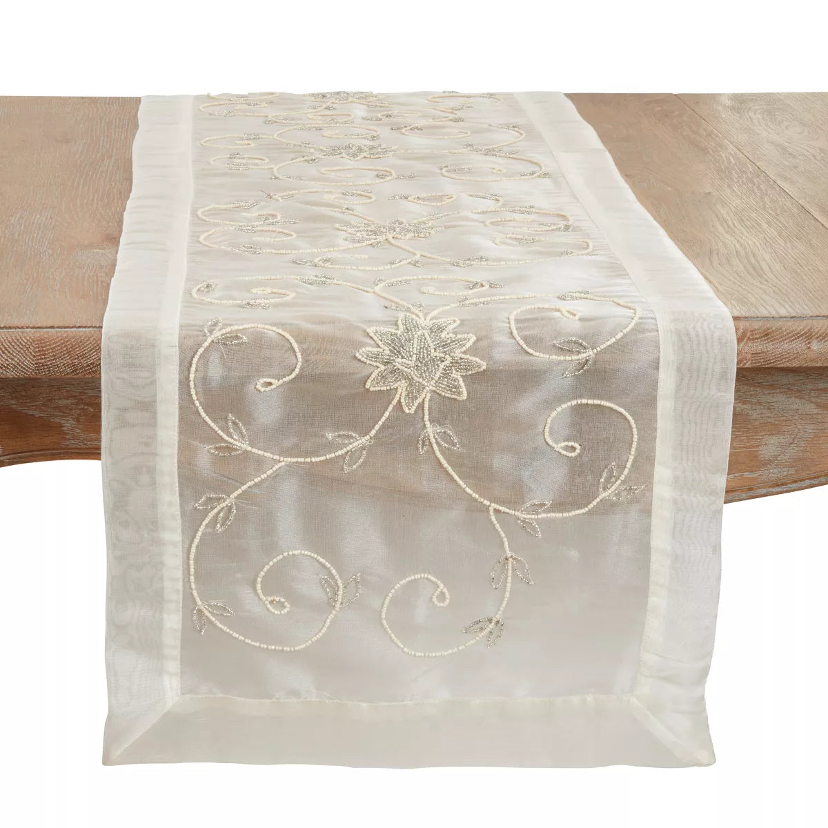 Embroidered table runner with floral design on a wooden table
