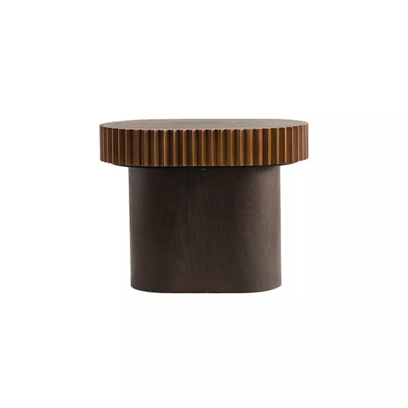 Wooden coffee table with a textured surface, featuring a book and flowers on top.
