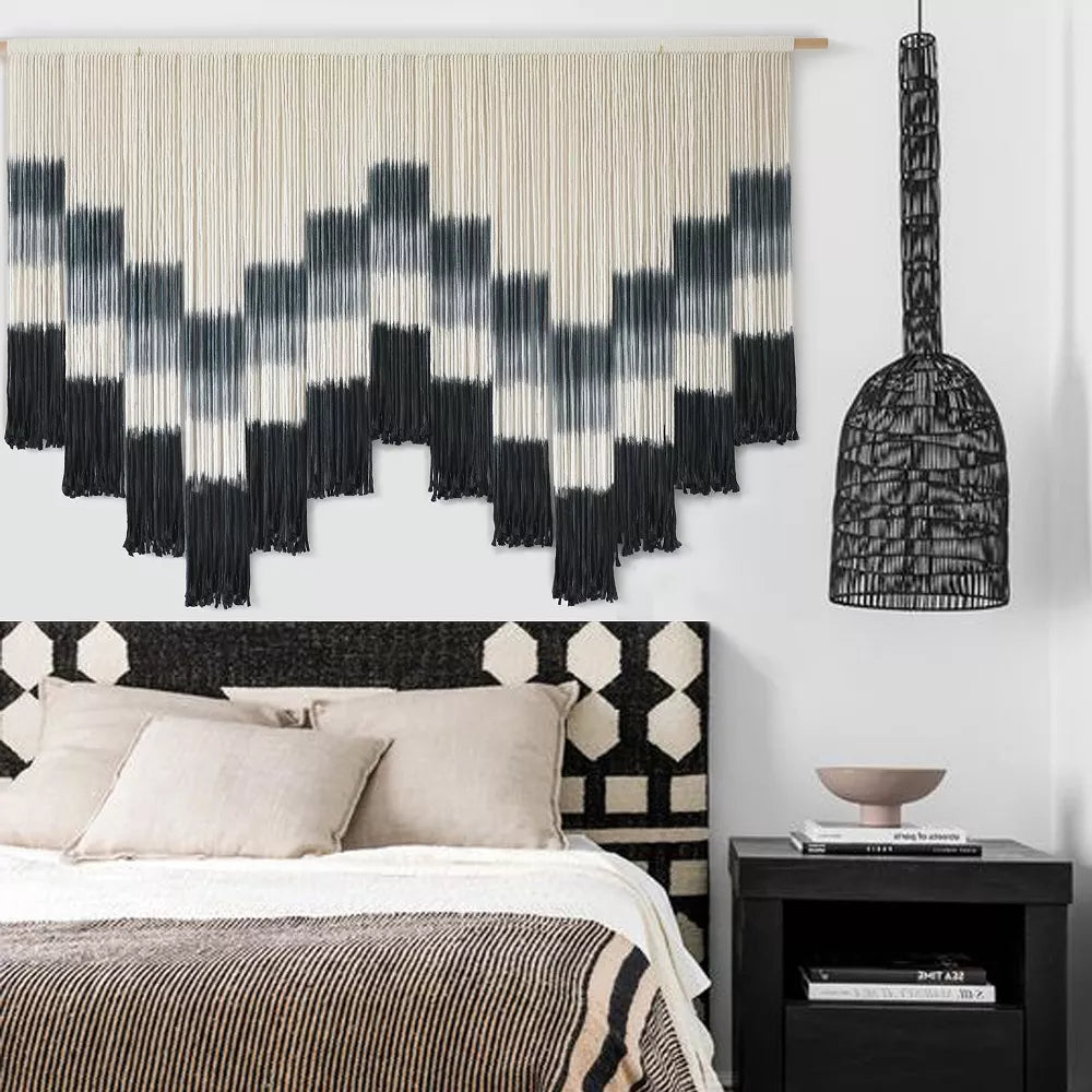 Black and white patterned wall art with fringe on a white background