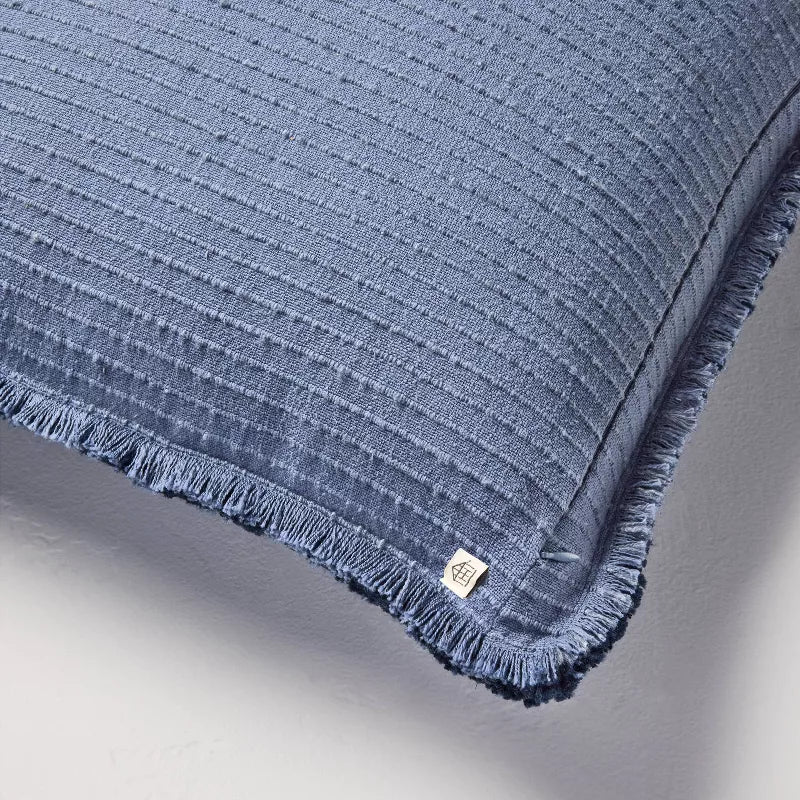 Blue textured blanket with frayed edges on a gray background Navy