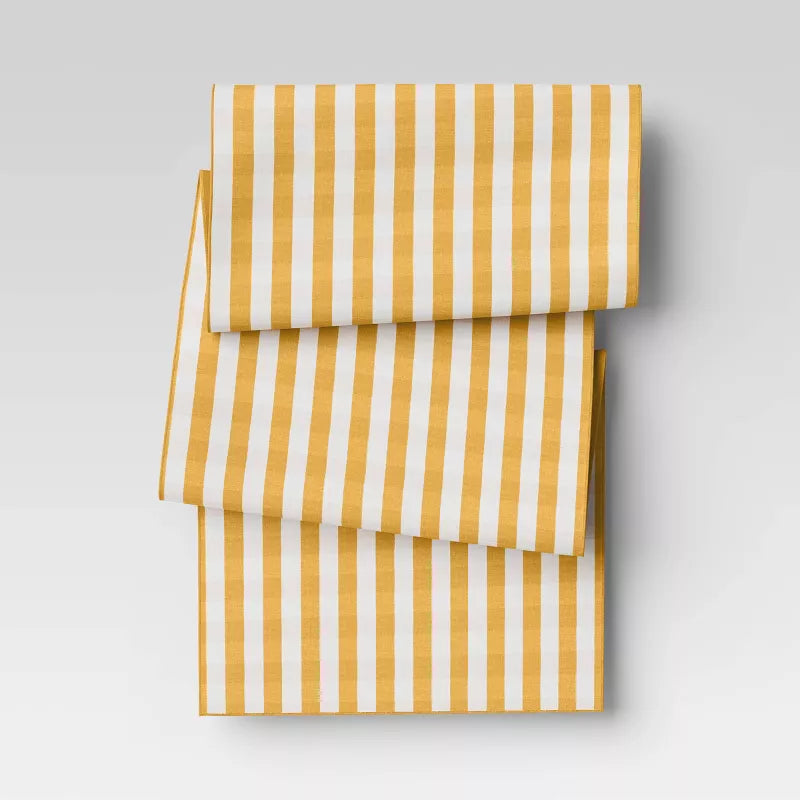 Yellow and white striped fabric on a light gray background