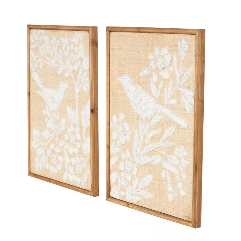 Two framed wall art pieces with white floral and bird designs on a beige background.