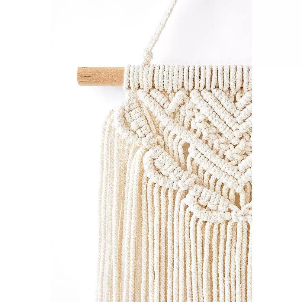 Macrame wall hanging with geometric pattern on a white background