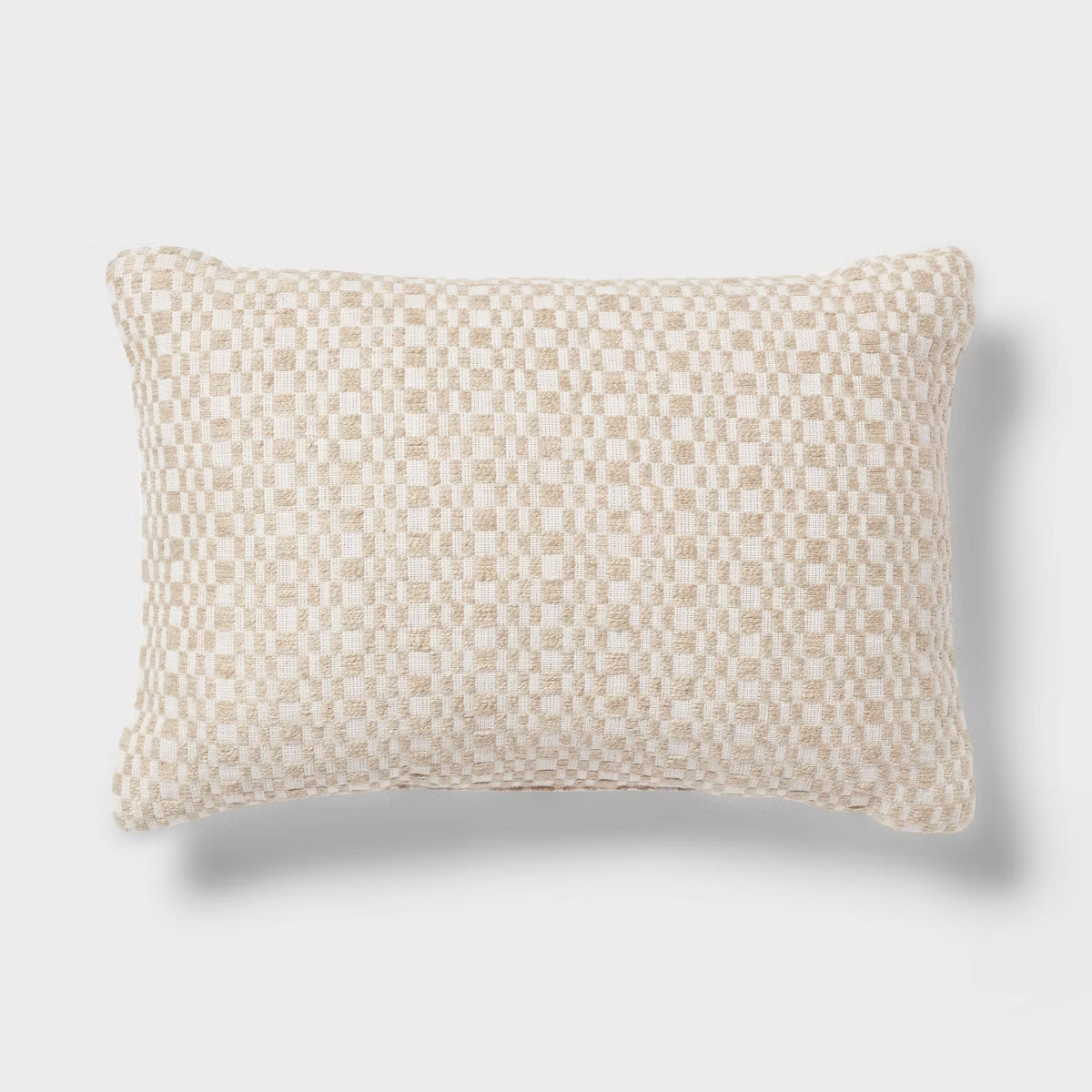 A rectangular throw pillow with a textured woven checkerboard pattern in cream and beige, shown against a light gray background with a soft drop shadow.