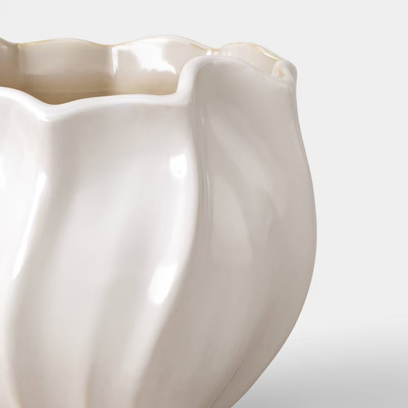 A white colored planter with a wavy, scalloped edge and smooth, glossy finish.