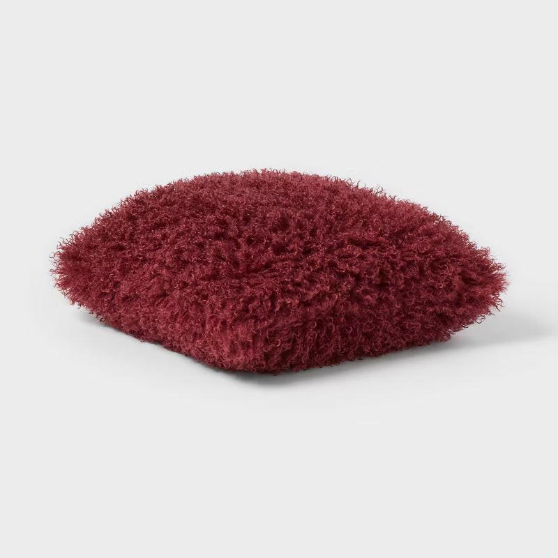 Fluffy red-brown cushion on a light gray background Berry Purple