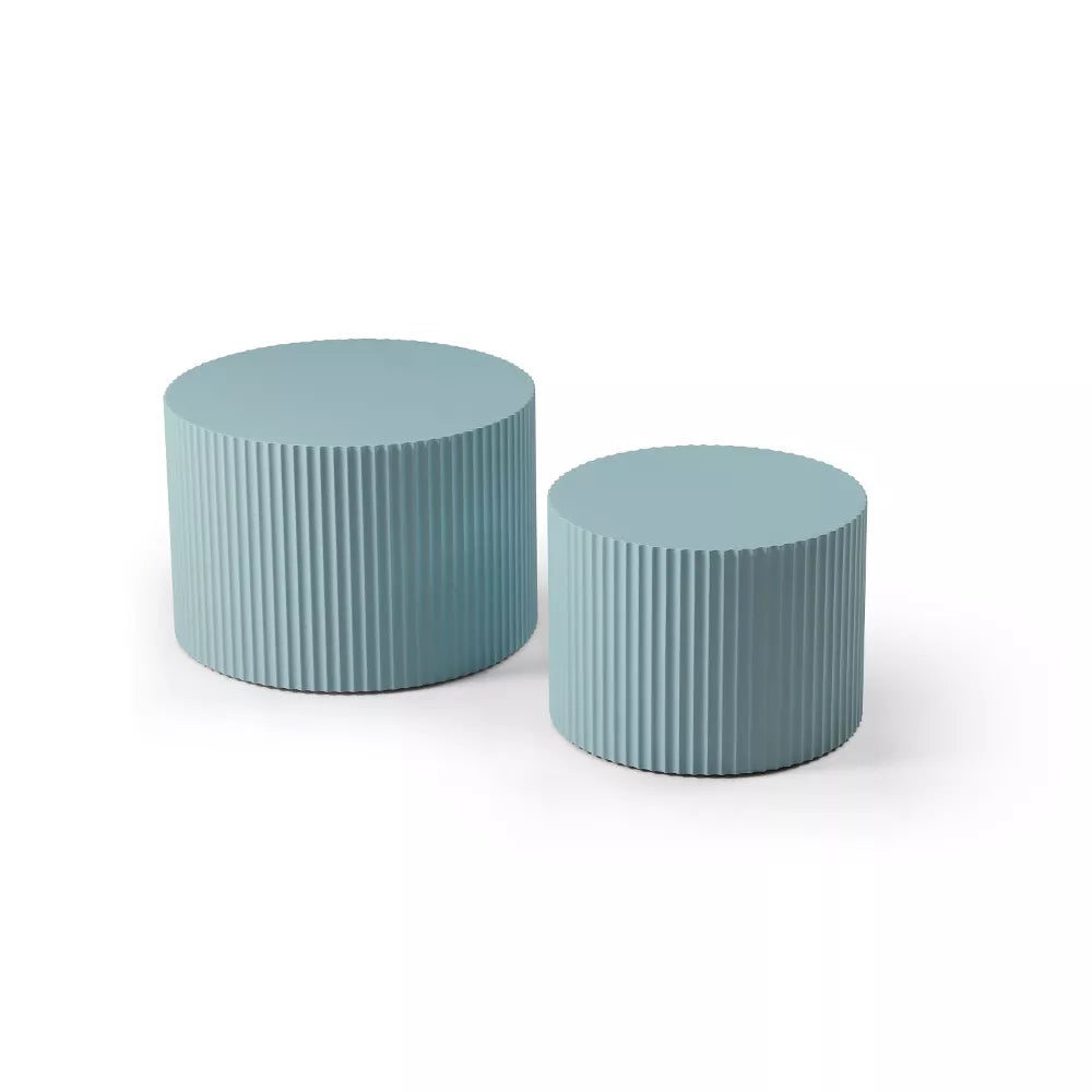 Blue ribbed side table with a magazine on top, featuring a plant and white vase.blue