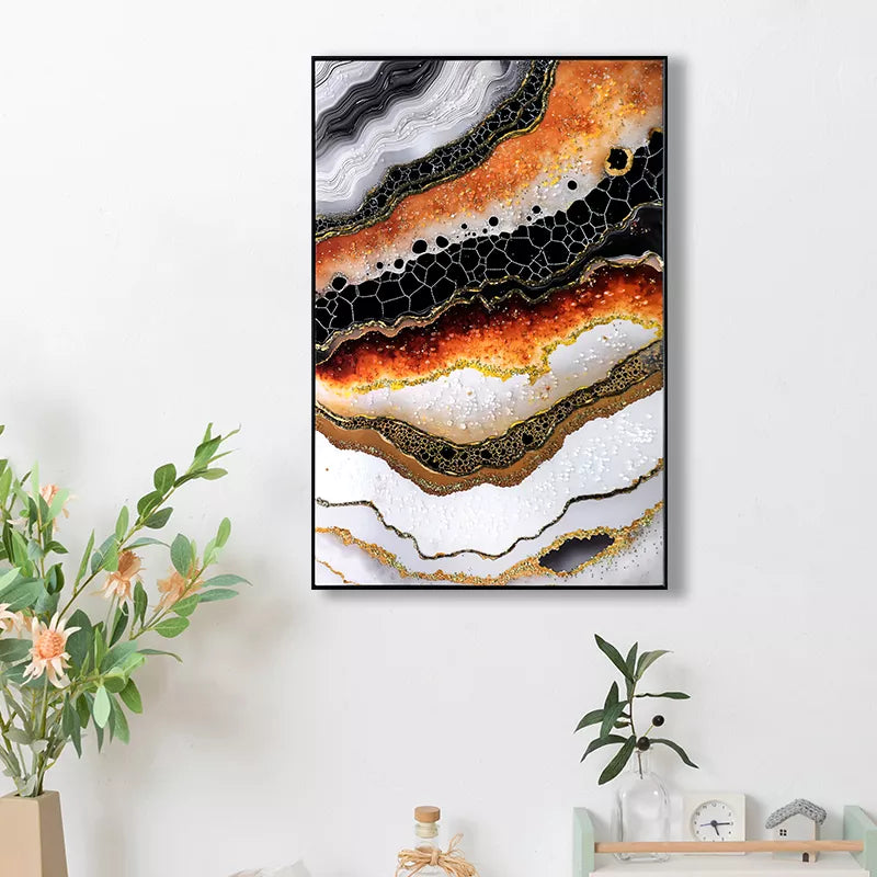 Framed abstract art piece on a wall with decorative plants and shelves below.