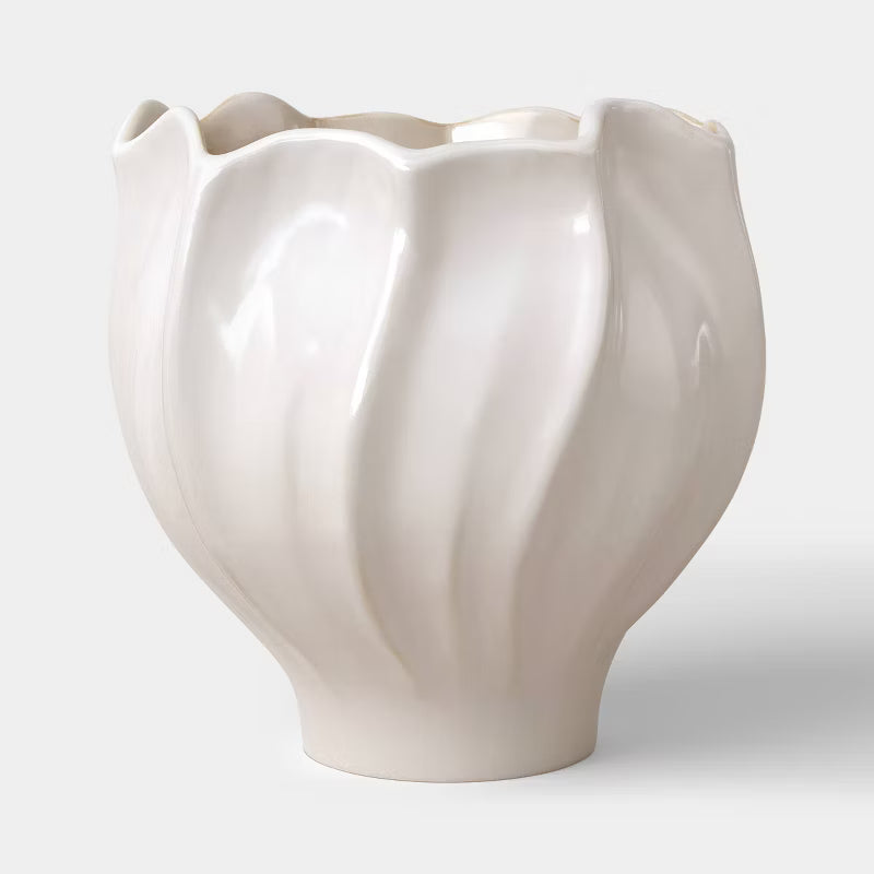 A white colored planter with a wavy, scalloped edge and smooth, glossy finish.
