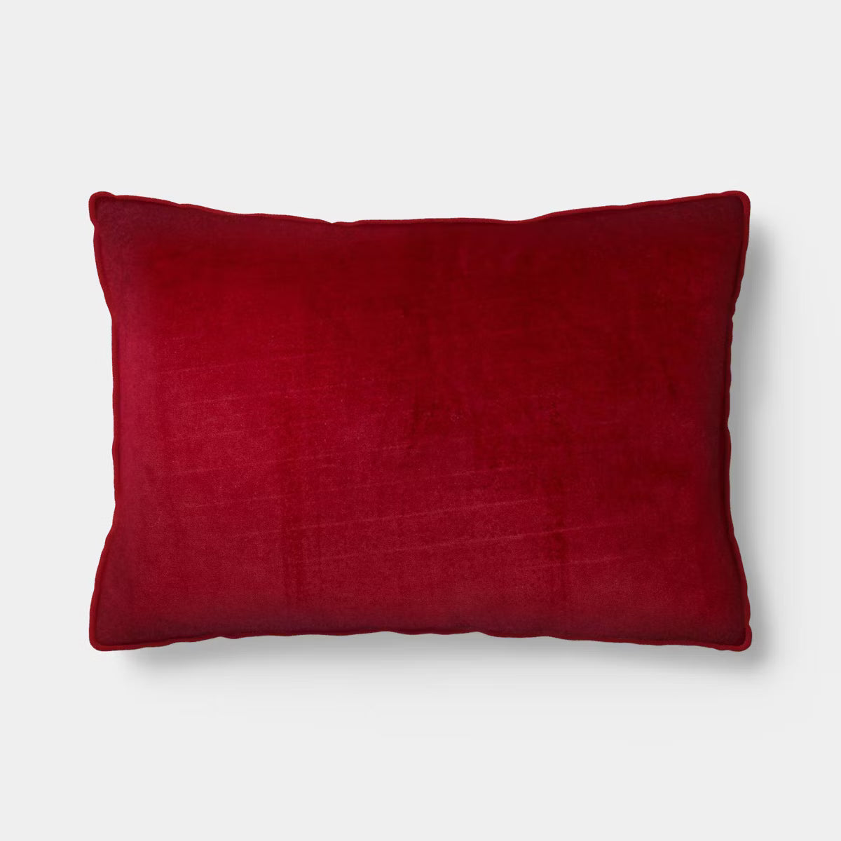 Rectangular light pink colored pillow with red colored piping and the word & quot love quot embroidered in red.