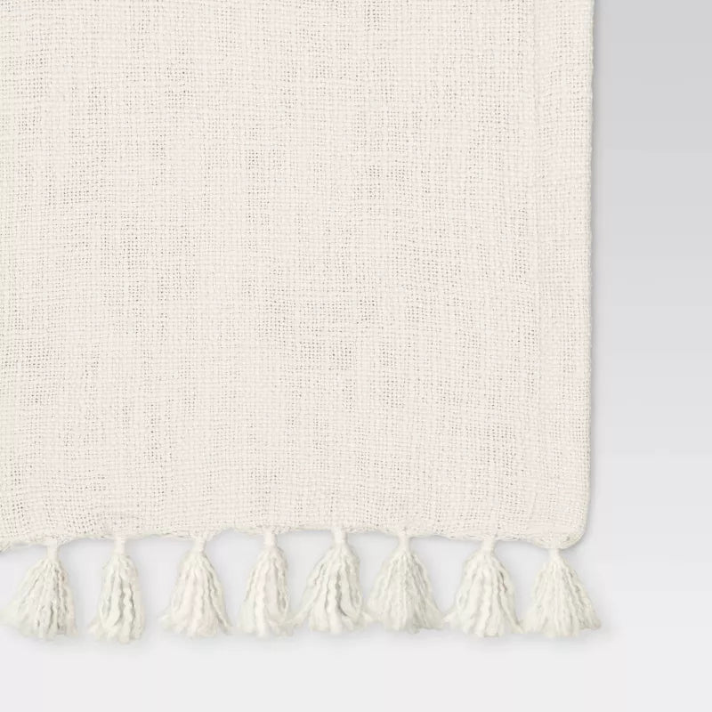 Beige rug with tassels on a light gray background