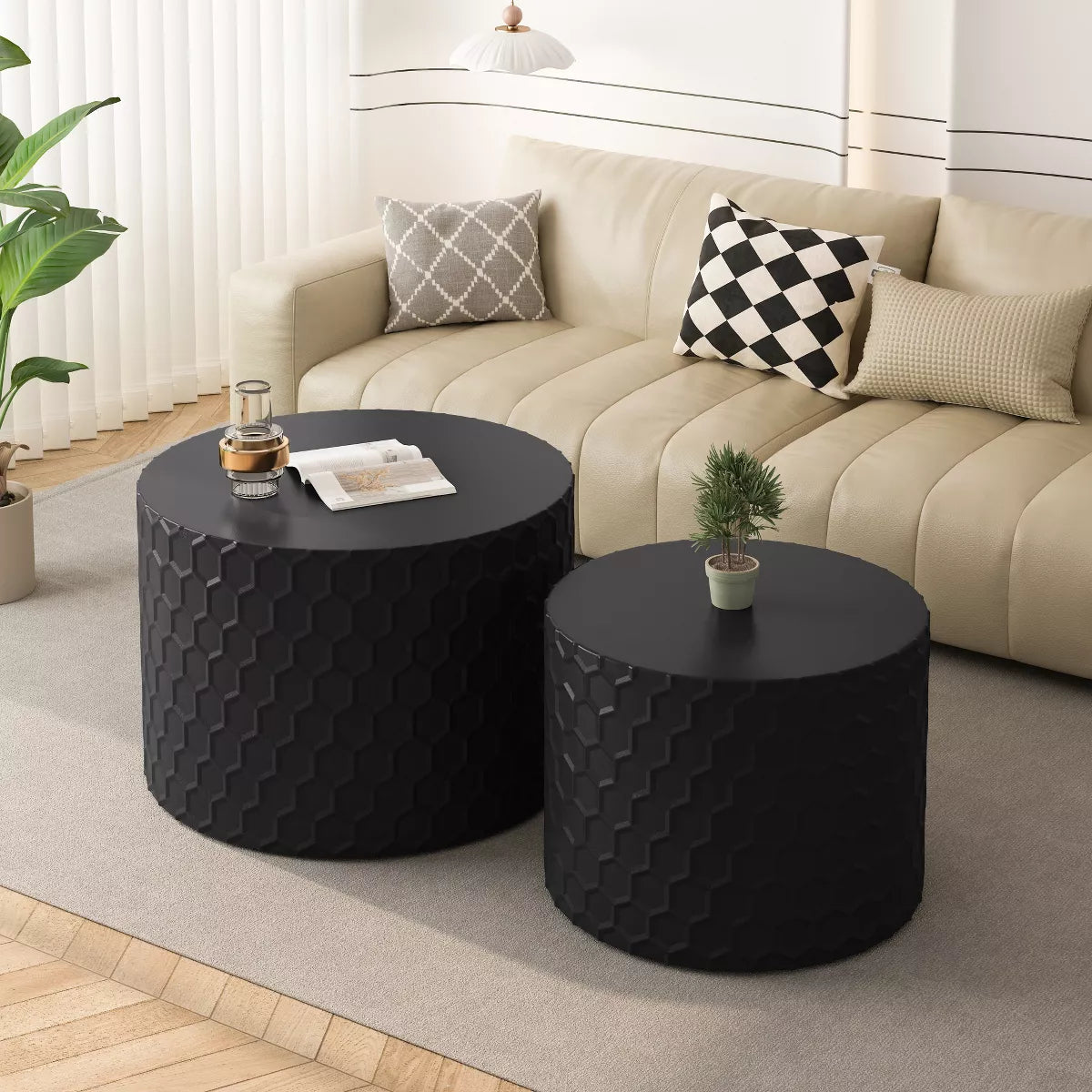 Two black textured side tables in front of a beige sofa with decorative pillows. black