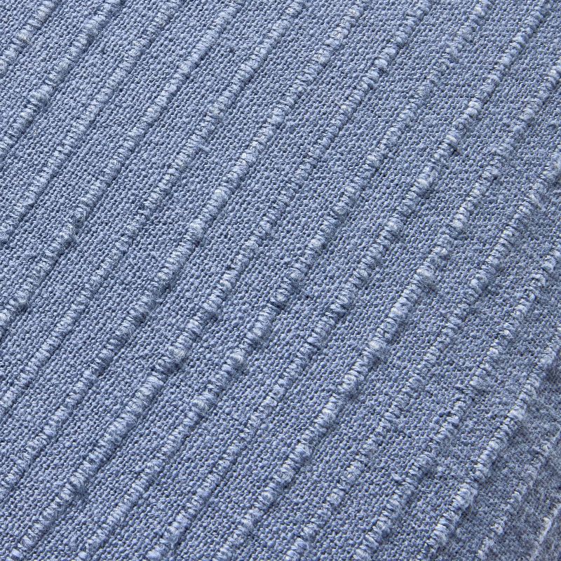 Blue textured blanket with frayed edges on a gray background Navy